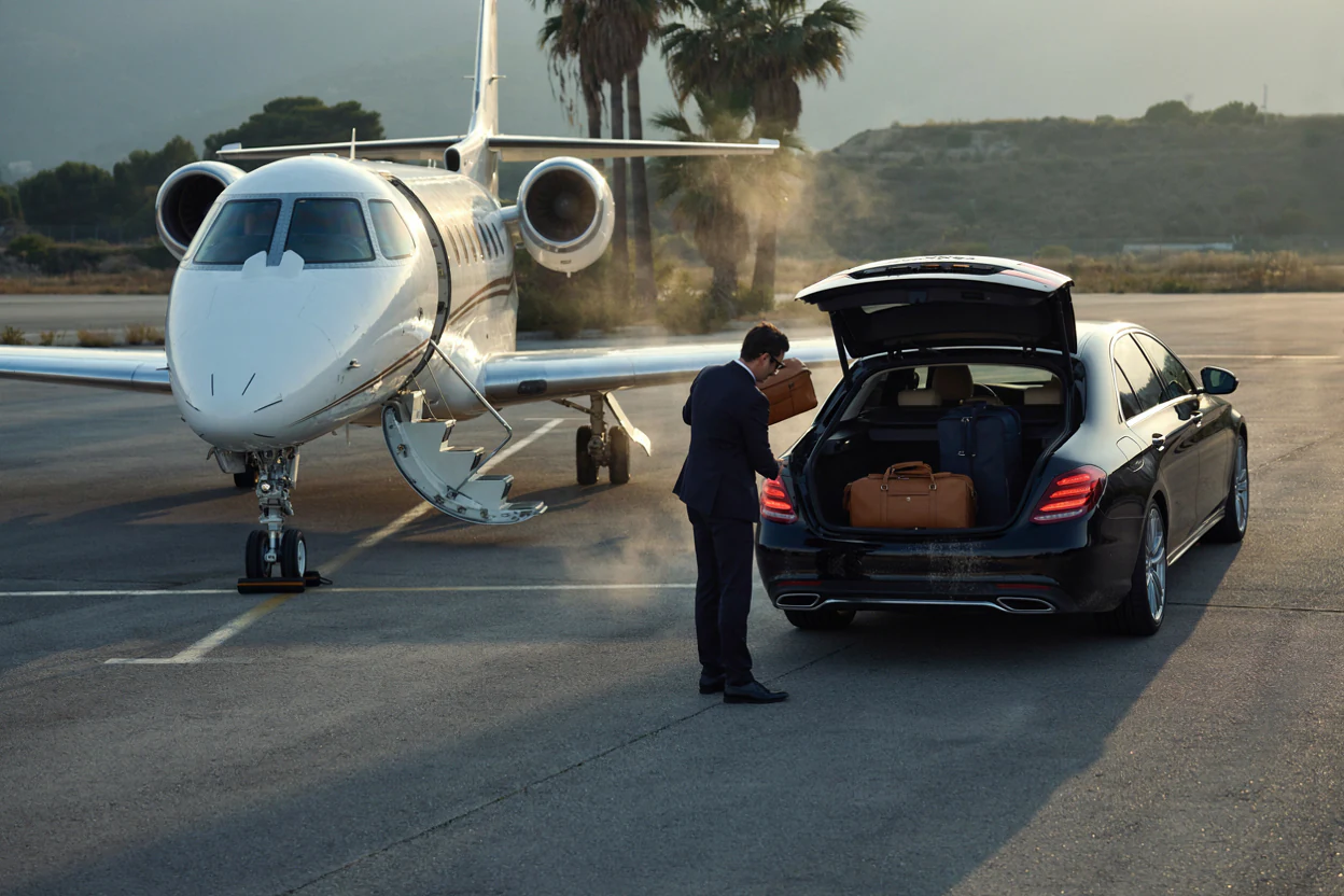A chauffeur loading luggage beside a jet in the south of France